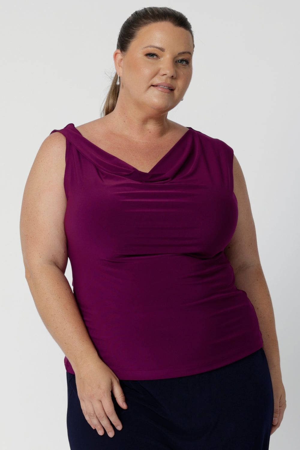 The twisted shoulder detail adds a subtle yet striking touch, elevating the design with a unique, contemporary flair. Plus size woman wears her Jordan top paired back with navy skirt.