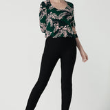 The Jules top in alpine is a green leaf printed top with a scoop neckline. Jersey top with 3/4 sleeves. Made in Australia for women size. 8 - 24. Styled back with black brooklyn pants.