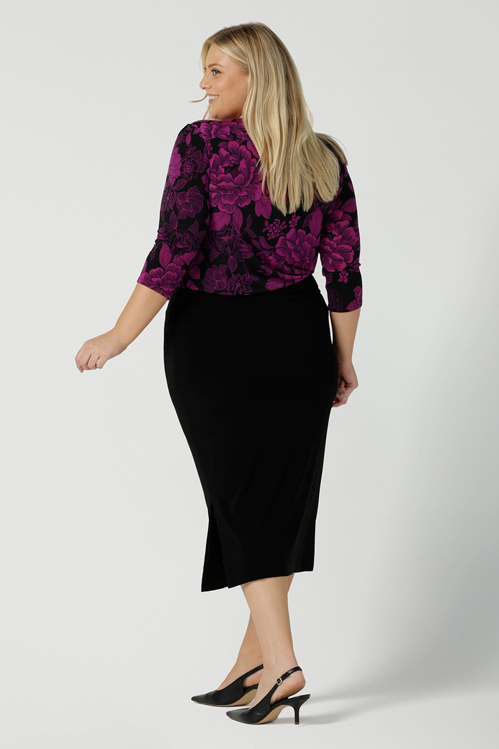 Back view of a size 18 woman wears the Jules top in Fuchsia Flora with a scoop neckline and 3/4 sleeves. Comfortable and easy care jersey fabric perfect for work to dinner style. Made in Australia for women size 8 - 24.