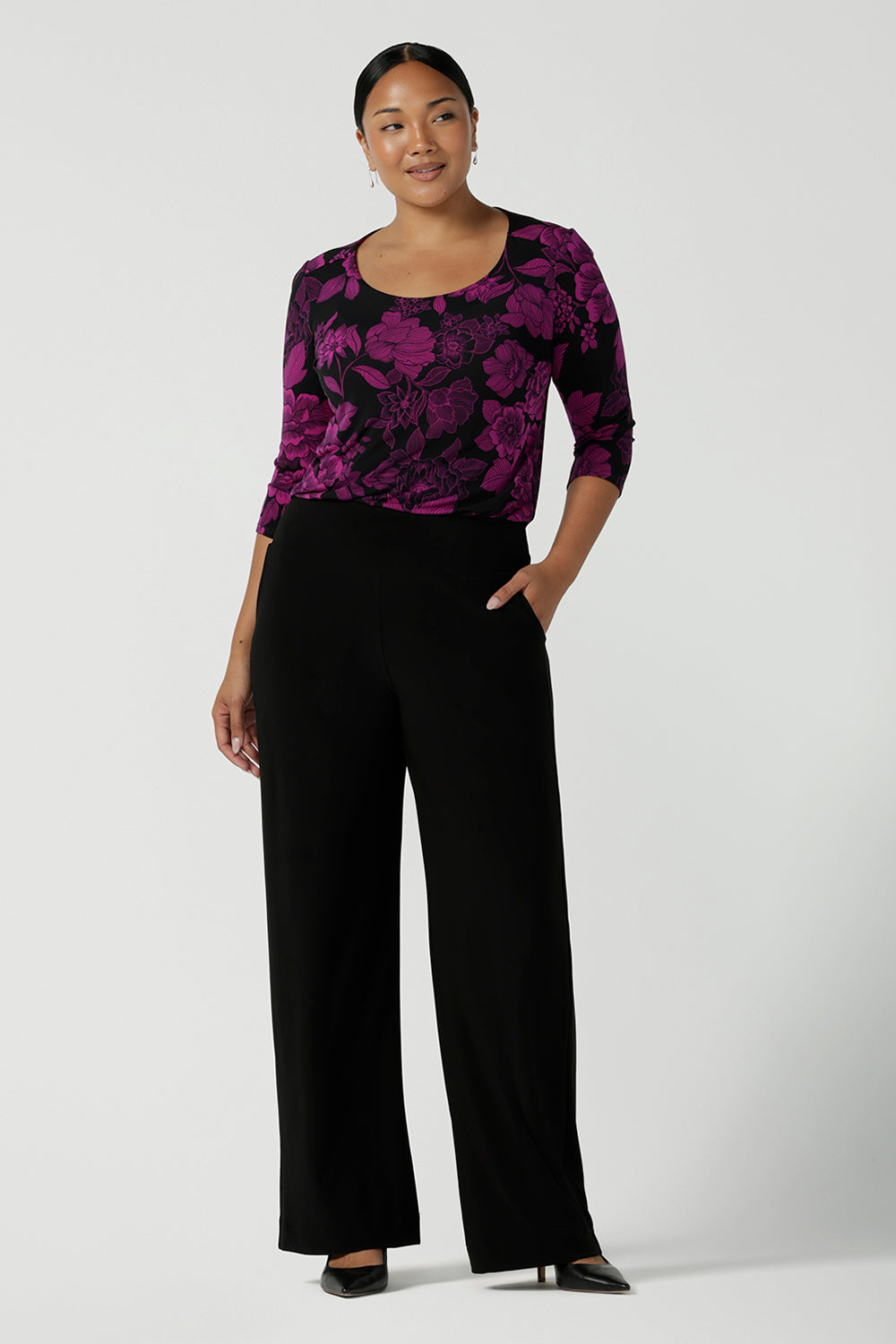 Size 10 woman wears the Jules top in Fuchsia Flora with a scoop neckline and 3/4 sleeves. Comfortable and easy care jersey fabric perfect for work to dinner style. Made in Australia for women size 8 - 24.