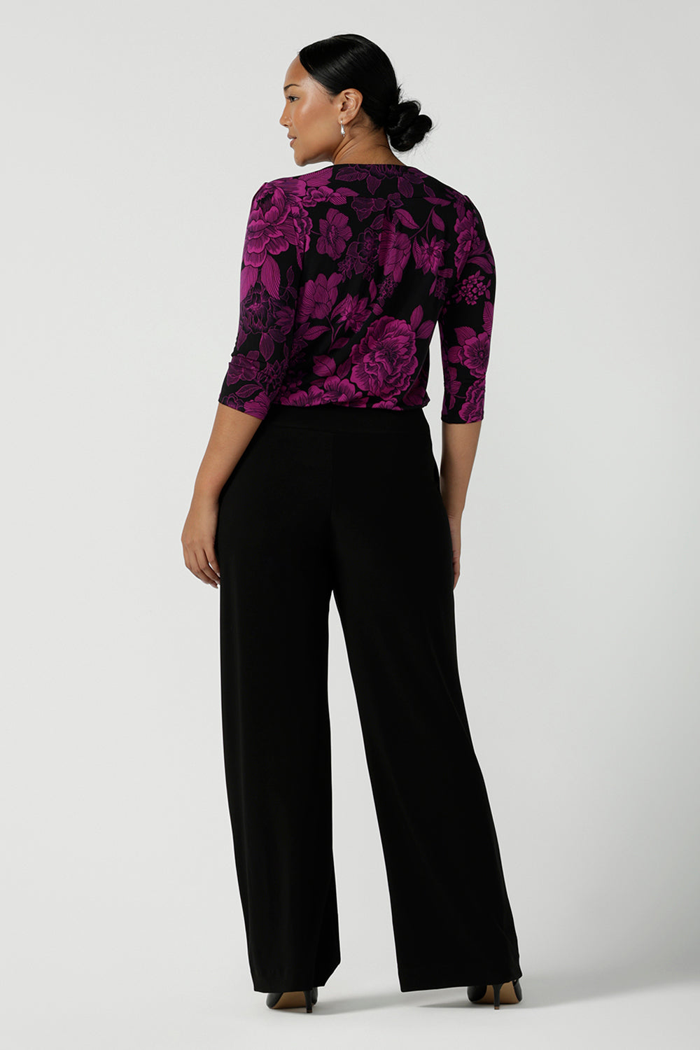 Back view of a size 10 woman wears the Jules top in Fuchsia Flora with a scoop neckline and 3/4 sleeves. Comfortable and easy care jersey fabric perfect for work to dinner style. Made in Australia for women size 8 - 24.