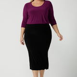 Back view of a size 18 woman wears the Jules top in Magenta. A soft jersey easy care 3/4 sleeve top ion rich purple magenta colour. Scoop neckline and made in Australia for women size 8 - 24. Styled back with an Andi Tube skirt in black. 