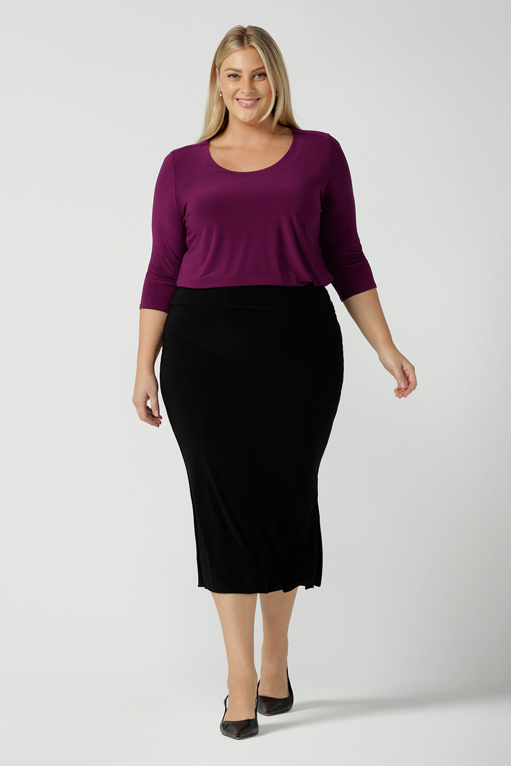 Back view of a size 18 woman wears the Jules top in Magenta. A soft jersey easy care 3/4 sleeve top ion rich purple magenta colour. Scoop neckline and made in Australia for women size 8 - 24. Styled back with an Andi Tube skirt in black. 