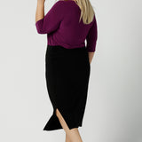 Back view of a size 18 woman wears the Jules top in Magenta. A soft jersey easy care 3/4 sleeve top ion rich purple magenta colour. Scoop neckline and made in Australia for women size 8 - 24. Styled back with an Andi Tube skirt in black.