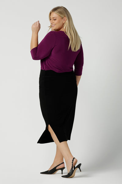 Back view of a size 18 woman wears the Jules top in Magenta. A soft jersey easy care 3/4 sleeve top ion rich purple magenta colour. Scoop neckline and made in Australia for women size 8 - 24. Styled back with an Andi Tube skirt in black.