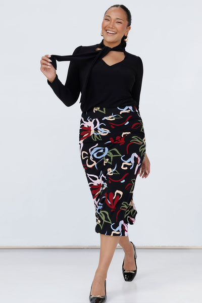 Size 10 woman wears the Andi tube skirt in Boronia, a slim fit midi skirt with Boronia matisse inspired print. Styled back with the Thom top n black and black pump heels. Made in Australia for women size 8 to 24. 