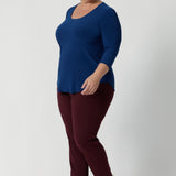 Workwear top pairs effortlessly with our Blazers, making it an essential piece for any corporate wardrobe. Whether dressing for the office or a weekend outing, the Jules Top provides the perfect balance of style, comfort, and versatility. Plus size model wears basic top with tapered leg pants to create simple yet elegant outfit.