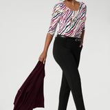 Size 10 woman wears printed scoop neck top with black tapered pants and wine coloured blazer. The vibrant Rainbow Zebra print, featuring shades of pink, taupe, and navy, adds a unique, eye-catching touch to a classic workwear look. Available in sizes 8-24.