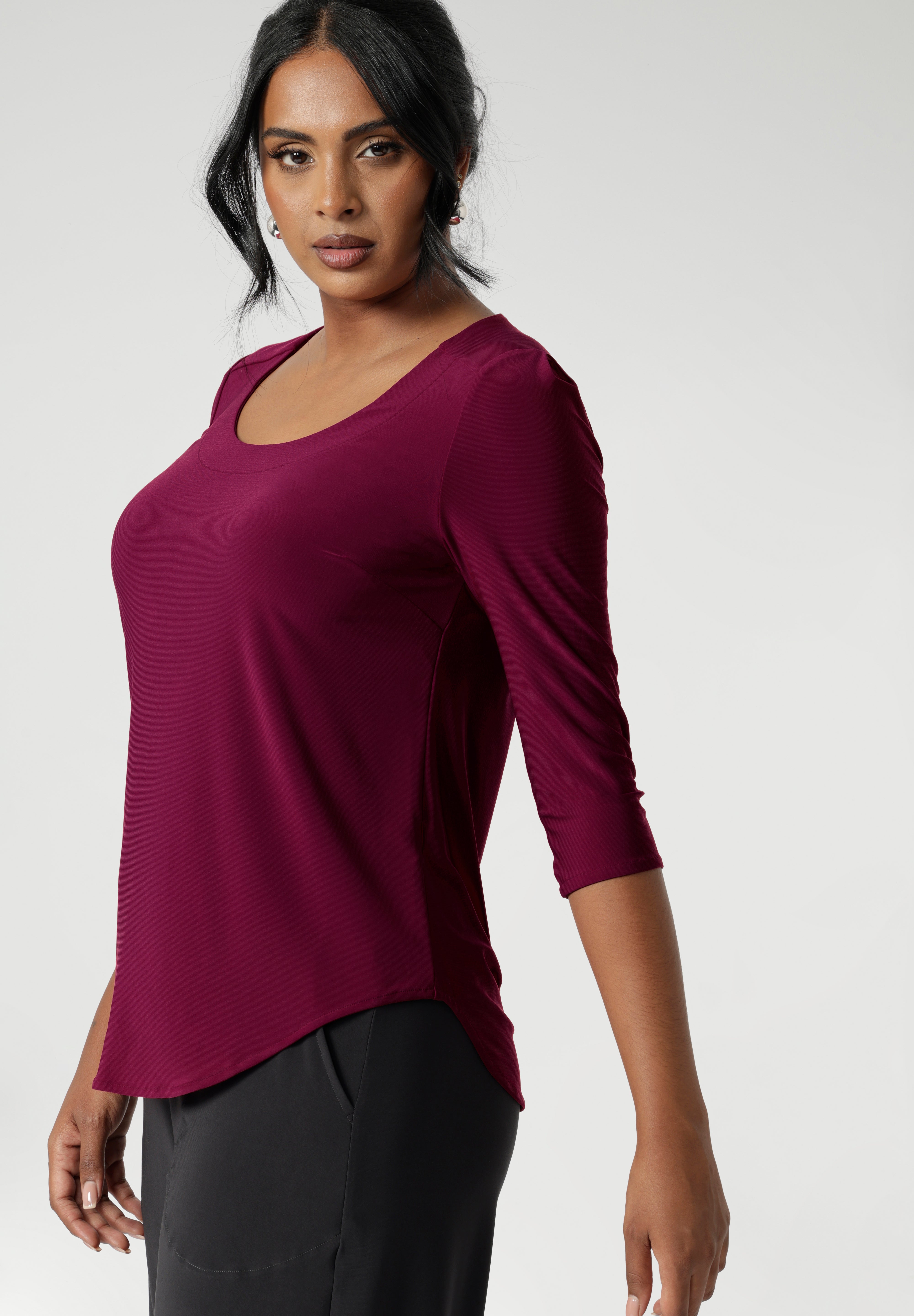 The semi-fitted silhouette creates a flattering shape, while the round neckline with a topstitched facing adds a clean, refined look. The 3/4 sleeves, with tucks at the sleeveheads, bring a touch of elegance, and the back shoulder yoke with a central pleat below provides a relaxed yet structured feel