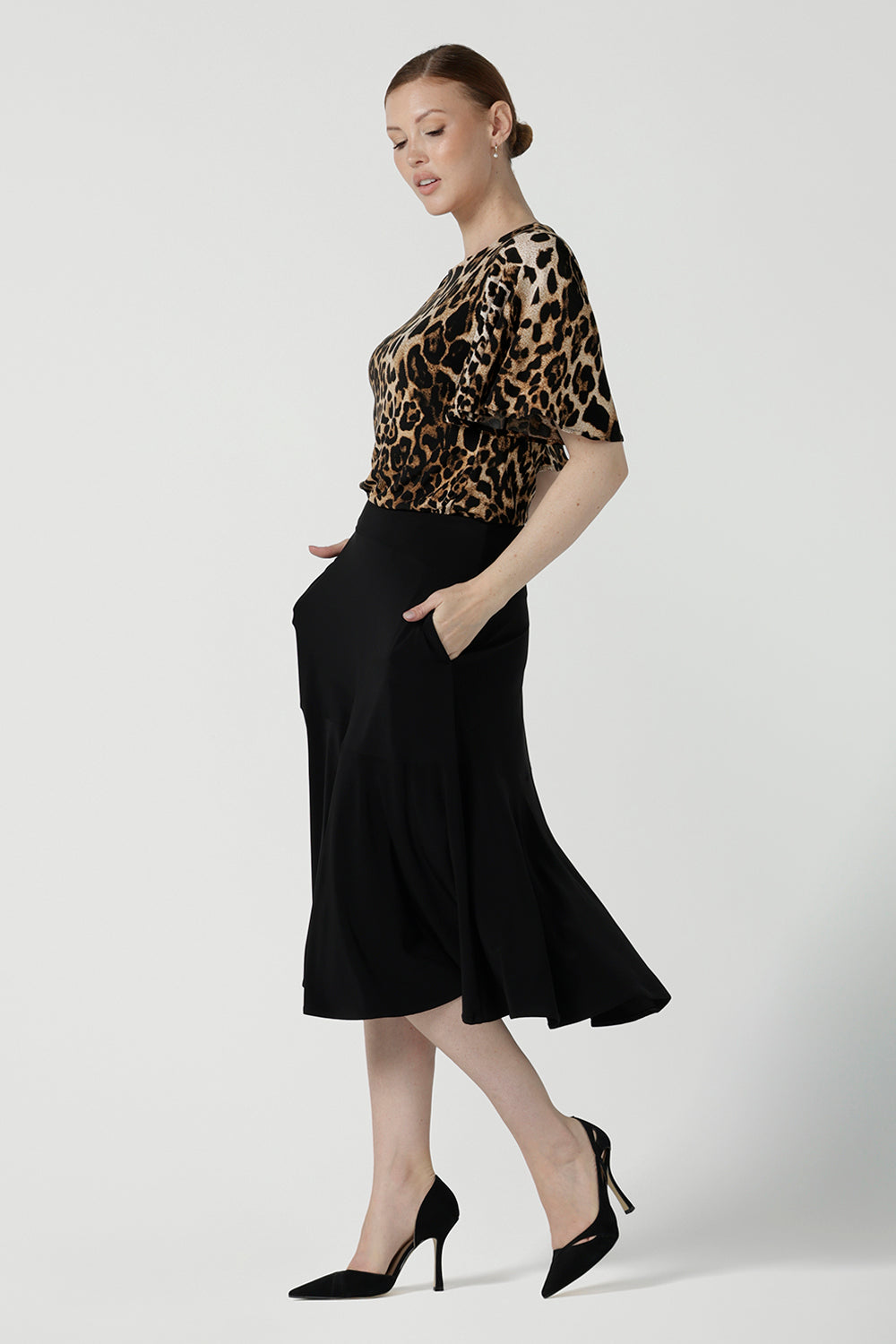 Back view of a size 10 woman wears the Juniper top in Gold Leopard. A flutter sleeve jersey top with flutter sleeves. Leina & Fleur are an Australian made fashion label on the Gold Coast Australia. Offering Petite to Plus size fashion 8 - 24. Comfortable workwear for women.