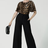 A size 10 woman wears the Juniper top in Gold Leopard. A flutter sleeve jersey top with flutter sleeves. Leina & Fleur are an Australian made fashion label on the Gold Coast Australia. Offering Petite to Plus size fashion 8 - 24. Comfortable workwear for women.