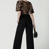 Back view of a size 10 woman wears the Juniper top in Gold Leopard. A flutter sleeve jersey top with flutter sleeves. Leina & Fleur are an Australian made fashion label on the Gold Coast Australia. Offering Petite to Plus size fashion 8 - 24. Comfortable workwear for women.