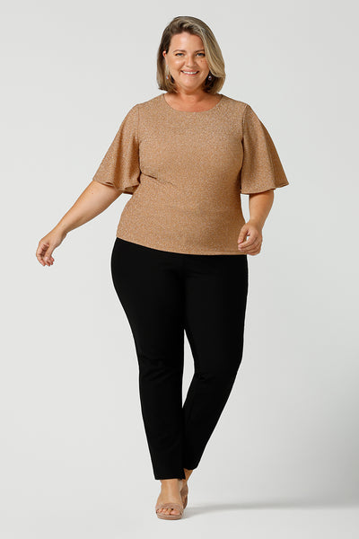 A size 18, fuller figure woman wears a sparkly honey glam top with flutter. Sleeves. Made in Australia by Australian and New Zealand women's clothing company, this shimmer jersey top wears well with evening and occasion-wear skirts, pants and suit jackets.