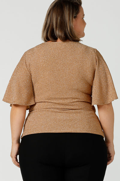 A size 18, fuller figure woman wears a sparkly honey glam top with flutter. Sleeves. Made in Australia by Australian and New Zealand women's clothing company, this shimmer jersey top wears well with evening and occasion-wear skirts, pants and suit jackets.