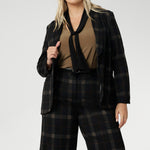 Designed for women who want style that works across occasions, this jersey top blends comfort with quiet sophistication. The soft V-neckline is accented by attached neck ties in a warm coffee tone, offering styling versatility. Plus zie woman wears her neck tie top under plaid suit set with matching blazer and wide leg pants.