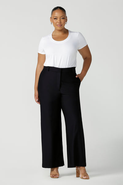 A good full length trouser for plus size women, these Navy blue, tailored wide leg pants are shown on a size 18, curvy woman. Worn with a short sleeve, white bamboo jersey top, these elegant pants wear for work as smart casual wear. Shop made in Australia trousers for women online at women's clothing brand Leina & Fleur.