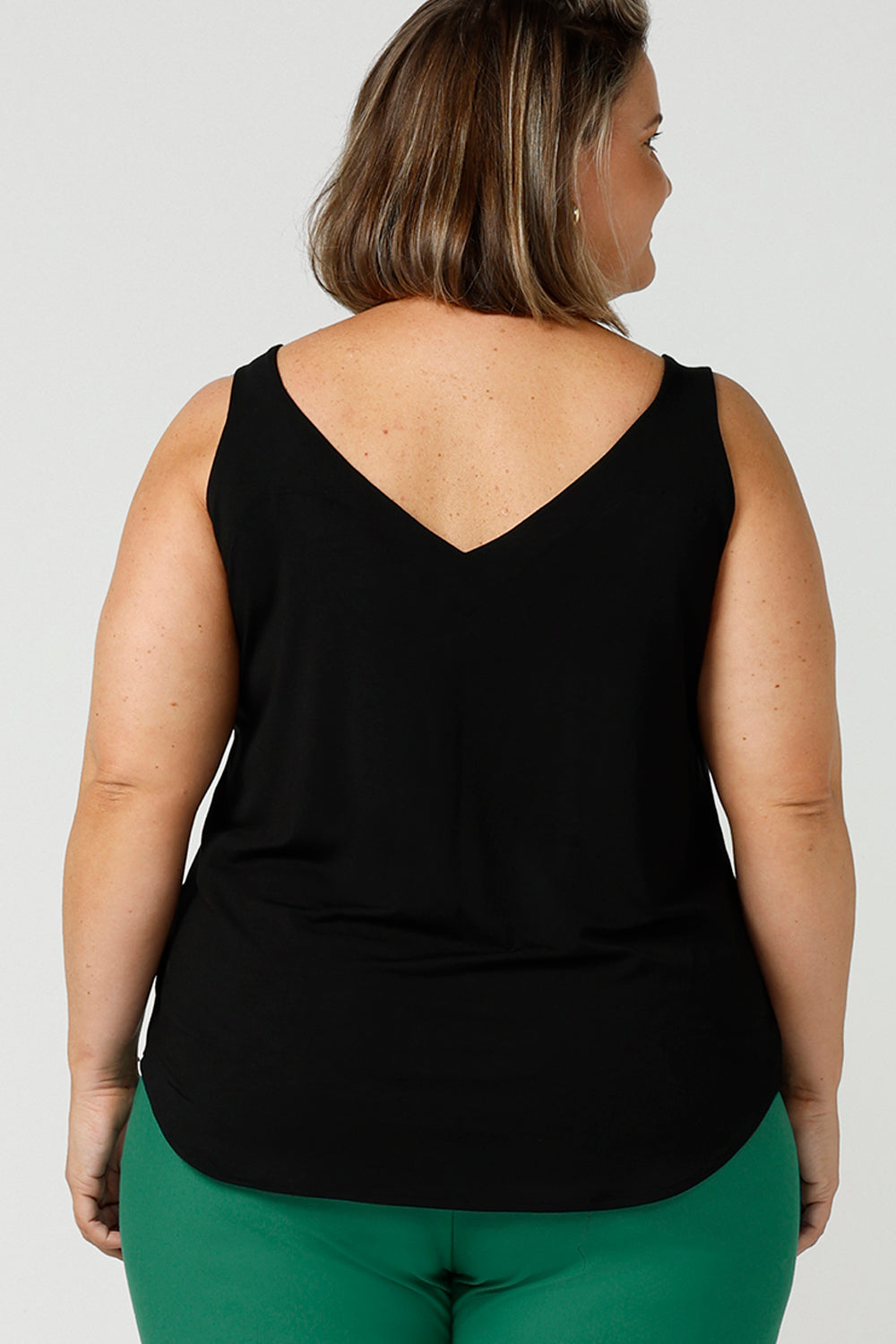 Back view of a size 18, fuller figure woman wears a bamboo cami. In black bamboo jersey, this top is a good addition to your capsule wardrobe for weekend wear, work and travel. Shop Australian-made dresses online is sizes 8 to 24.