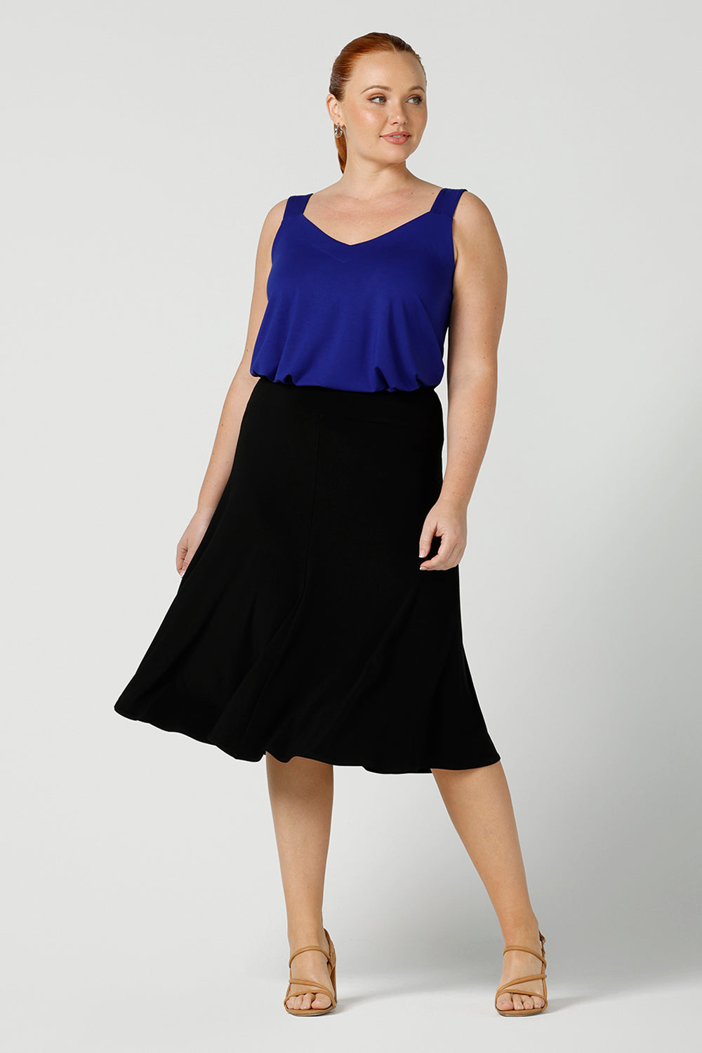 A black skirt by Australian made clothing brand Leina & Fleur, this knee length, A-line skirt falls softly in black jersey. A comfortable skirt for petite to plus size workwear, this skirt is shown on a size 12, curvy woman and worn with a cobalt blue cami in bamboo jersey. A good black skirt for your capsule wardrobe, shop skirts at Leina & Fleur's online clothing boutique Australia.