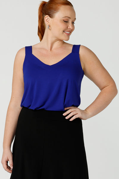 Close up of a size 12, curvy woman wears a bamboo cami. In cobalt blue bamboo jersey, this top is a good addition to your capsule wardrobe for weekend wear, work and travel. Shop Australian-made dresses online is sizes 8 to 24.