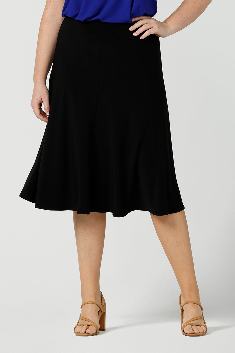 A black skirt by Australian made clothing brand, Leina & Fleur, this knee length, A-line skirt falls softly in black jersey. A comfortable skirt for petite to plus size workwear, this skirt is shown on a size 12, curvy woman. A good black skirt for your capsule wardrobe, shop skirts in sizes 8 to 24 at Leina & Fleur's online clothing boutique Australia.