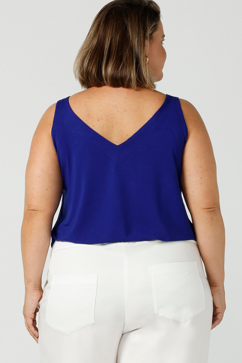 Back view of a plus size 18, curvy woman wears a bamboo cami. In cobalt blue bamboo jersey, this top is a good addition to your capsule wardrobe for weekend wear, work and travel. Shop Australian-made dresses online is sizes 8 to 24.