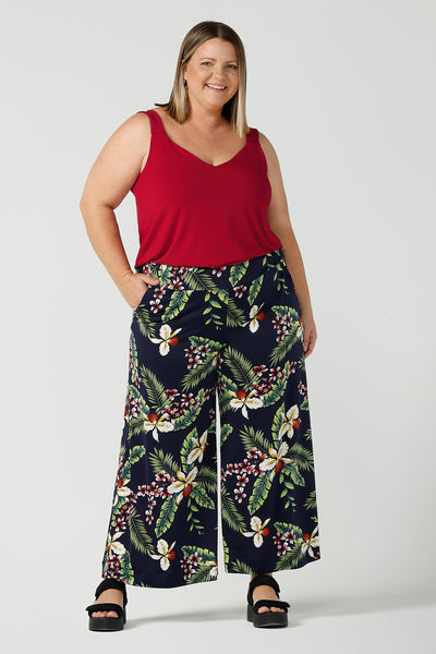 A curvy size 18 happy woman wears a red bamboo Kai cami top. Breathable bamboo material is breathable and temperature regulating. Styled back with a Merriment print Jersey wide leg pant. Made in Australia for women sizes 8 - 24.