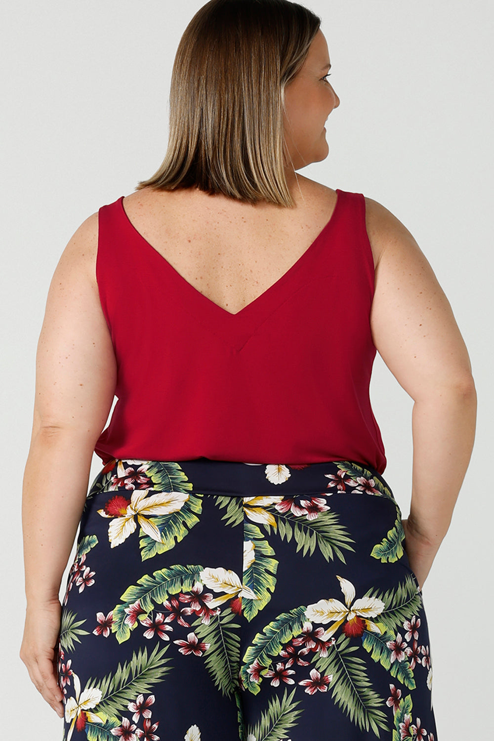 Back view of a curvy size 18 happy woman wears a red bamboo Kai cami top. Breathable bamboo material is breathable and temperature regulating. Made in Australia for women sizes 8 - 24.