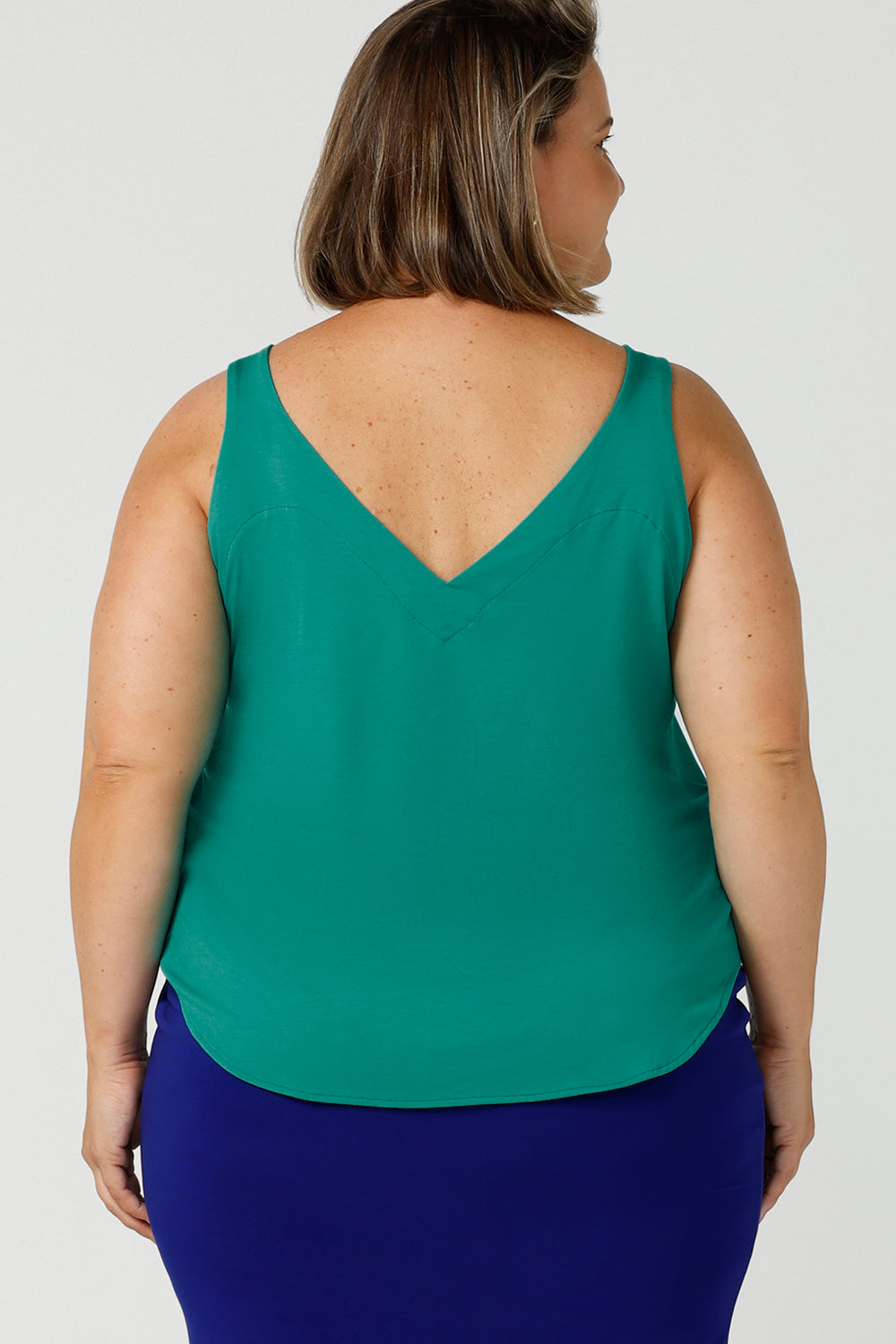 Back view close up of a plus size 18, curvy woman wears a bamboo cami. In jade green bamboo jersey, this top is a good addition to your capsule wardrobe for weekend wear, work and travel. Shop Australian-made dresses online is sizes 8 to 24.