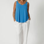 Size 12 woman wears summer cami, that features a shirt-tail hemline providing a relaxed, elongated silhouette, offering a flattering shape that drapes effortlessly over the body. Made from natural bamboo fibres, the fabric boasts exceptional thermoregulating properties, helping to cool the body on warm days and maintain comfort in fluctuating temperatures. This makes the cami perfect for travel, as it adapts to your environment, keeping you fresh and comfortable throughout your journey. Sizes 8-24