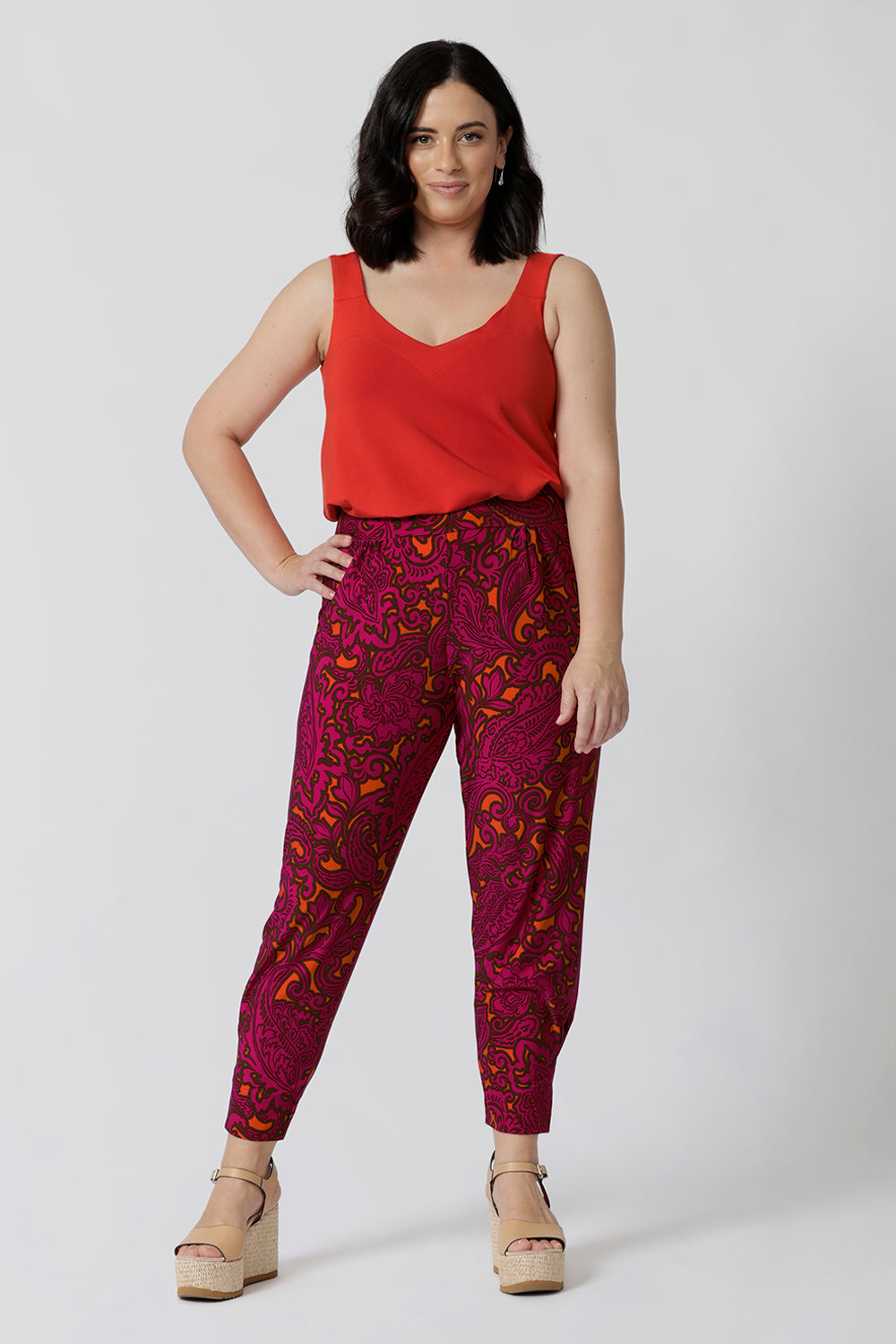 Petite model wears tangerine bamboo cami paired back with paisley printed pants for chic summer ensemble. V neck design featured in the front and back of the cami has been created to flatter every sizes through 8-24.