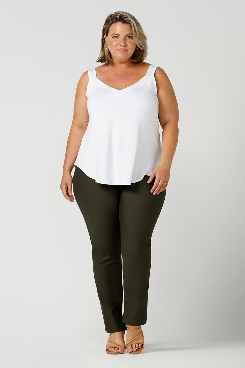 In olive green, these slim leg women's pants are great professional work and office wear trousers. Made in Australia by affordable, ethical clothing brand, Leina & Fleur this stretch pants are worn as casual pants with a white cami top in bamboo jersey and shown on a size 18, plus size woman. Shop ladies clothing online in petite to plus sizes at Leina & Fleur's online boutique.