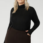 This black long-sleeve top is crafted from a luxurious blend of lightweight TENCEL™ and wool, offering breathable warmth without the bulk. The high turtleneck adds a cosy, refined touch, while built-in thumb holes provide extra coverage and comfort on cooler days.