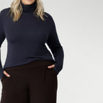 Size 18 woman wears long-sleeved top that features convenient thumb holes for added comfort and warmth and a high turtle neck. Crafted from lightweight, warm tencel wool fabric and in sizes 8-24.