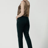 Back view of a size 10 woman wearing the Jonas Pant in green velveteen. A made in Australia velveteen pant styled back with the Eddy cami in Bullion Xanadu.