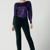 Front view of a size 10 woman wearing the Jonas Pant in green velveteen. A made in Australia velveteen pant styled back with the Purple Mikado top. 