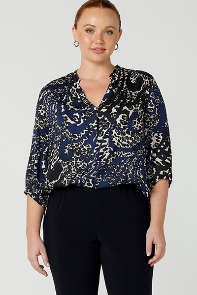 A size 12 woman wearing an animal print woven top with a swing back. This lightweight top is comfortable for your everyday workwear, casual and travel capsule wardrobe. Shop this Australian-made shirt online in sizes 8 to 24, petite to plus sizes.