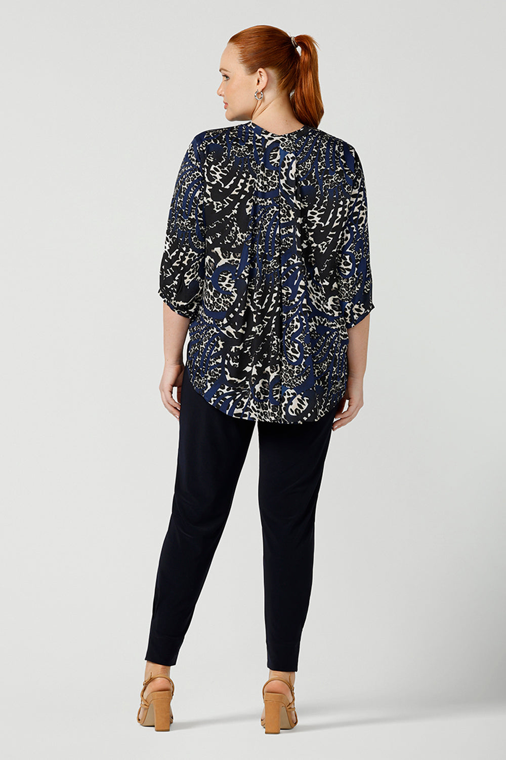 Back view of A size 12 woman wearing an animal print woven top with a swing back. This lightweight top is comfortable for your everyday workwear, casual and travel capsule wardrobe. Shop this Australian-made shirt online in sizes 8 to 24, petite to plus sizes.