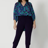 A good pant for petite women, the Indi Pant in Amethyst is worn with an oversized, 3/4 sleeve blouse. A pull-on pant in stretch jersey, these cropped length trousers make comfortable travel pants. Here, these purple pants are styled for evening and going out wear. 