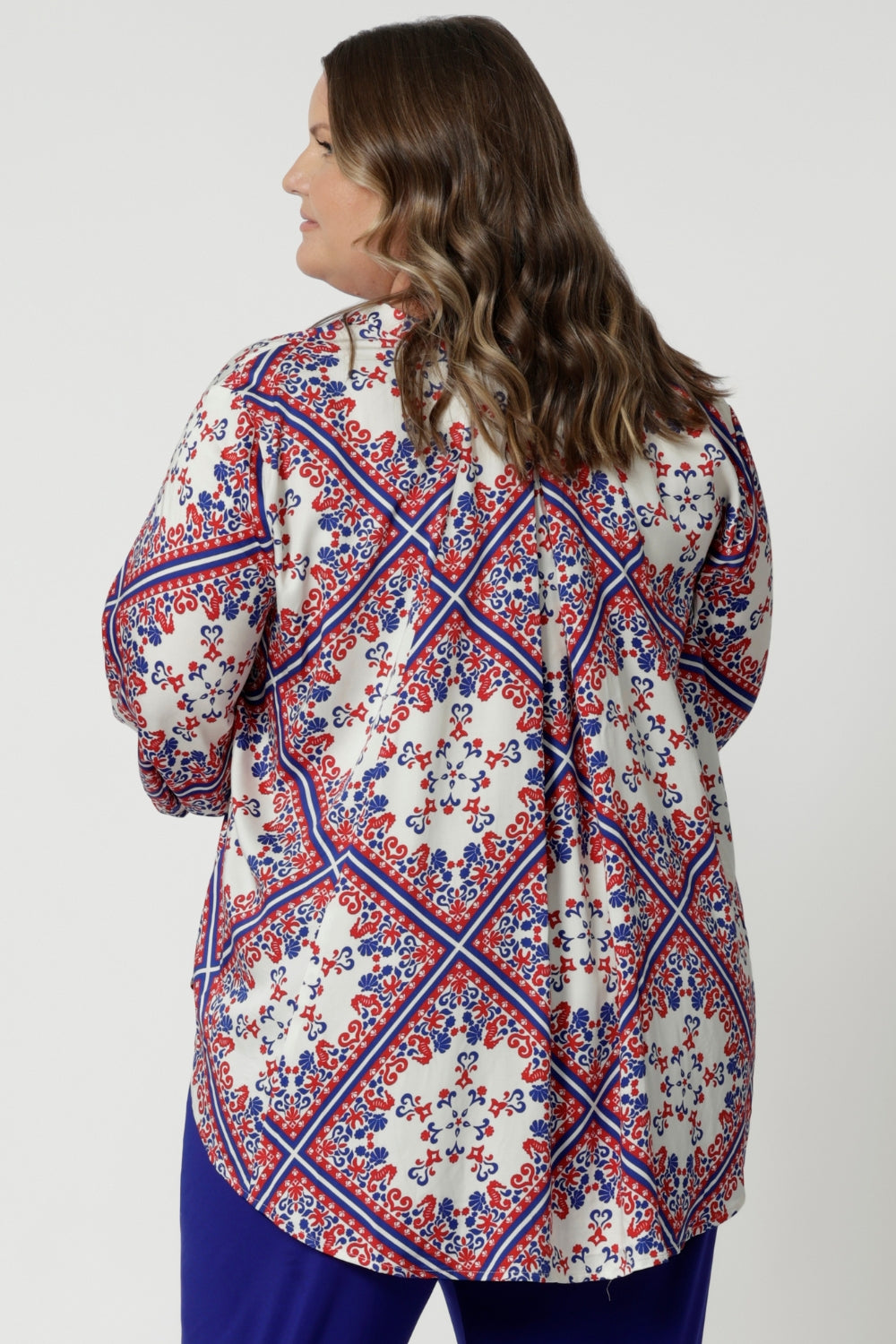 Plus sized woman wears elegant design 3/4-sleeved swing shirt. Playful and luxe fabric offer a versatile and stylish piece that will quickly become a favourite for warm-weather fancy occasions. Its combination of comfort, sophistication, and unique details make it the perfect addition to any summer wardrobe.