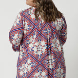 Plus sized woman wears elegant design 3/4-sleeved swing shirt. Playful and luxe fabric offer a versatile and stylish piece that will quickly become a favourite for warm-weather fancy occasions. Its combination of comfort, sophistication, and unique details make it the perfect addition to any summer wardrobe.