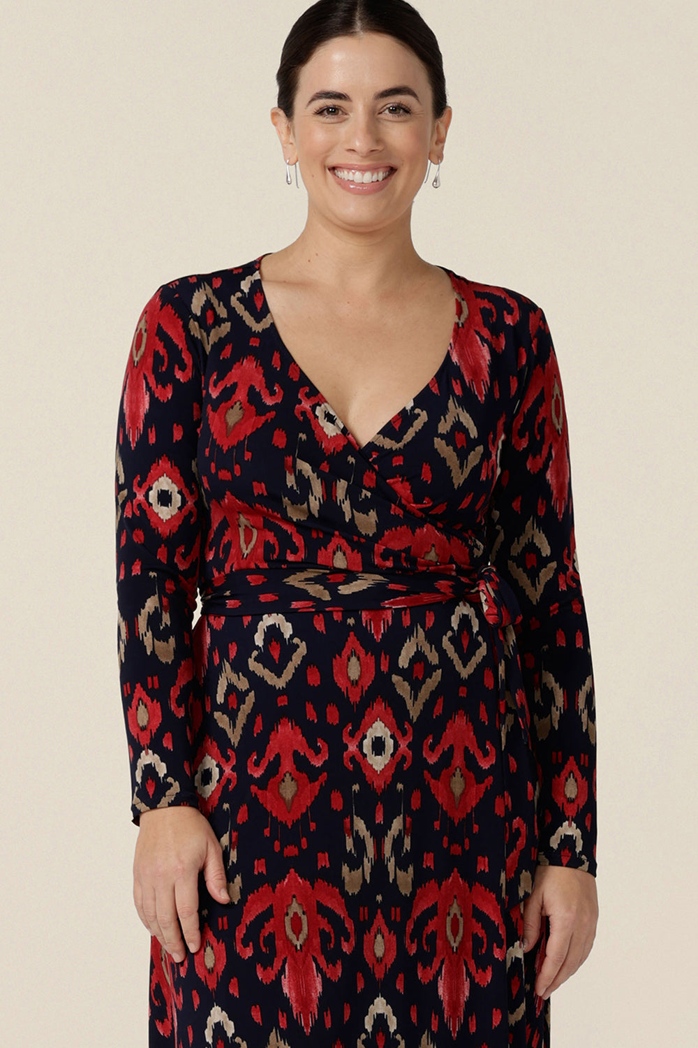 Close up an Australian-made maxi dress, the Kimberly Maxi Dress in Ikat is a full length jersey wrap dress with long sleeves. Shown on a size 10 woman, shop this maxi dress in an inclusive size range of sizes 8 to 24.