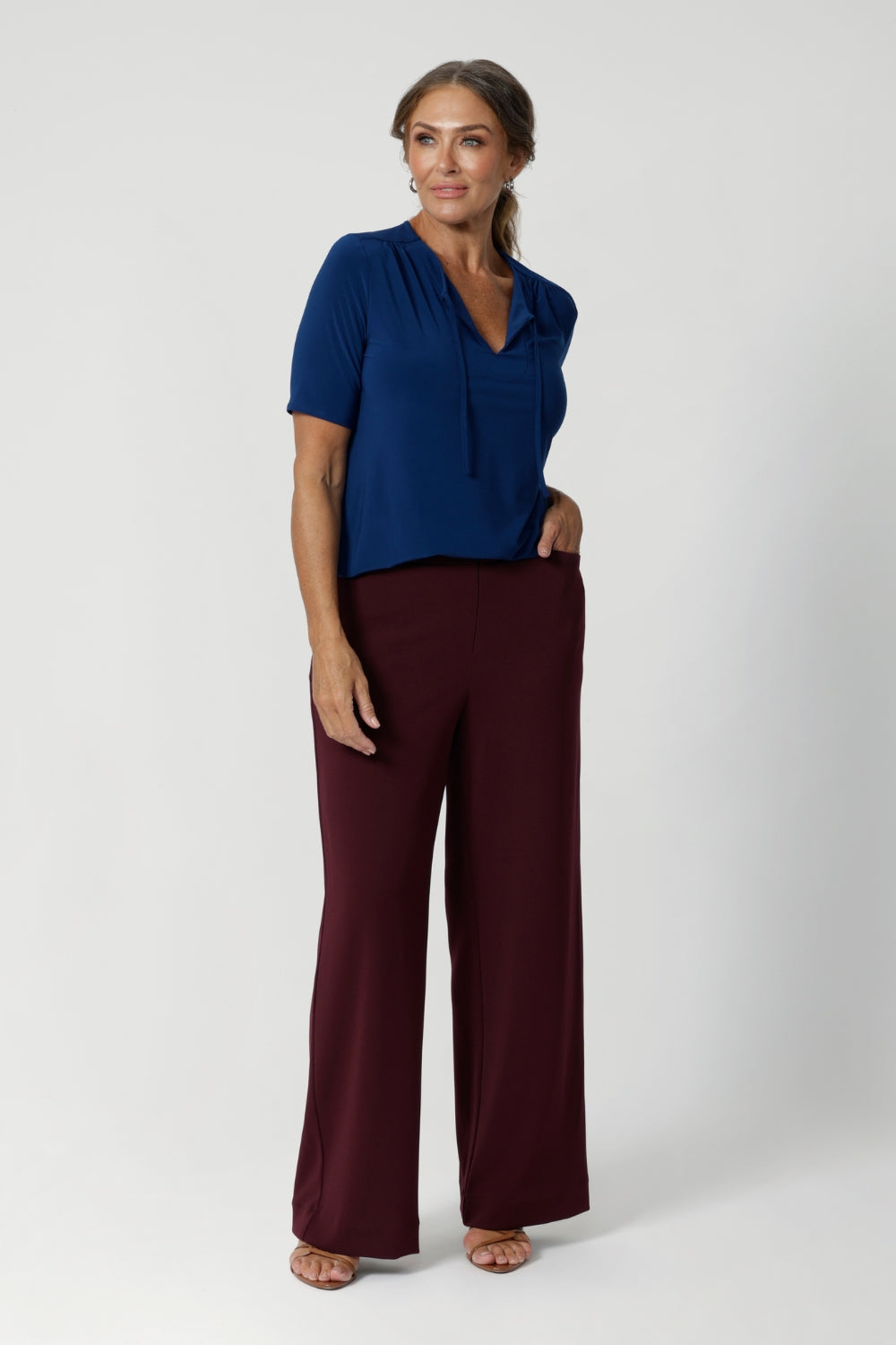 The top features elbow-length sleeves, offering just the right amount of coverage while maintaining a relaxed, airy vibe. The subtle stitching detail around the front-facing and thin fabric ties add a chic, tailored touch, while the soft gathers at the front.