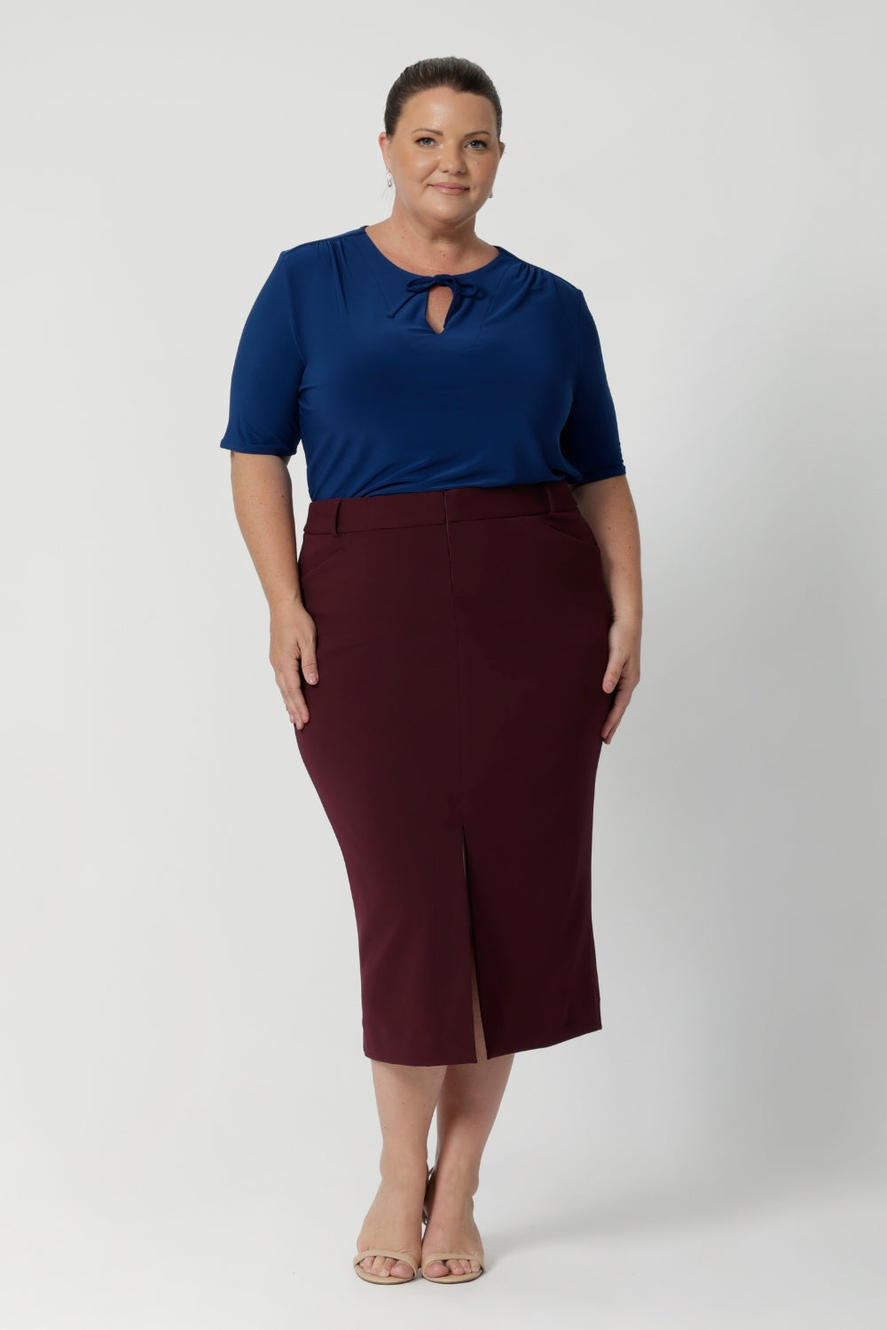 Plus size woman wears woman's workwear top with fabric neckties, that adds a tailored touch, perfect for elevating your everyday outfits. Size 18 woman wears her neckties tied up, creating a feminine and flattering key hole silhouette to the blouse that moves with you. Available in size 8-24.