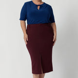 Plus size woman wears woman's workwear top with fabric neckties, that adds a tailored touch, perfect for elevating your everyday outfits. Size 18 woman wears her neckties tied up, creating a feminine and flattering key hole silhouette to the blouse that moves with you. Available in size 8-24.