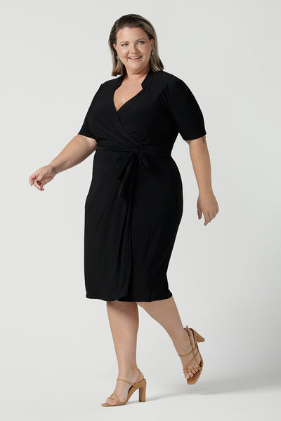 Size 18 woman wears the Kriss dress in black. A functioning wrap work dress in soft black jersey. Great for being comfortable in the office. Made in Australia for women size inclusive fashion 8 - 24.