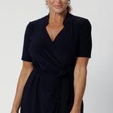 Kris dress in Navy is a functioning wrap dress in navy. Featuring a mandarin collar and short sleeves. Gathered at the waist with a functioning tie. Made in Australia for women size 8 - 24.