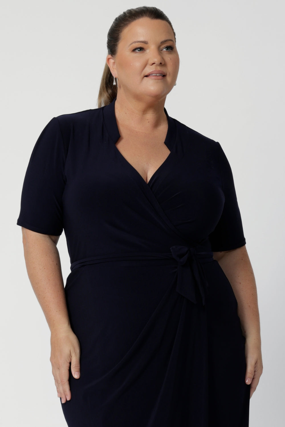 Kris dress in Navy in s a size 18 is a functioning wrap dress in navy. Featuring a mandarin collar and short sleeves. Gathered at the waist with a functioning tie. Made in Australia for women size 8 - 24.