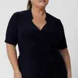 Kris dress in Navy in s a size 18 is a functioning wrap dress in navy. Featuring a mandarin collar and short sleeves. Gathered at the waist with a functioning tie. Made in Australia for women size 8 - 24.