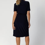 Kris dress in Navy in s a size 12 is a functioning wrap dress in navy. Featuring a mandarin collar and short sleeves. Gathered at the waist with a functioning tie. Made in Australia for women size 8 - 24.