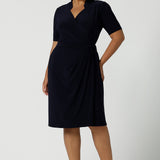 Kade dress in Navy in s a size 16 is a functioning wrap dress in navy. Featuring a mandarin collar and short sleeves. Gathered at the waist with a functioning tie. Made in Australia for women size 8 - 24.